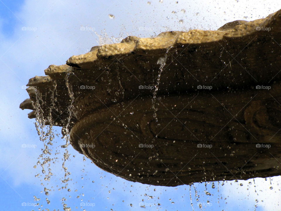 falling water from the stone fountain edge