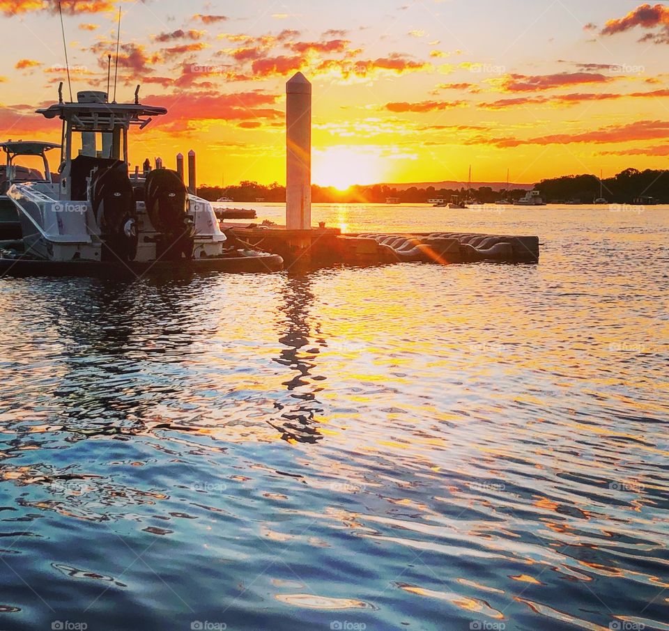 Sunset at the jetty on the lake with a boat 