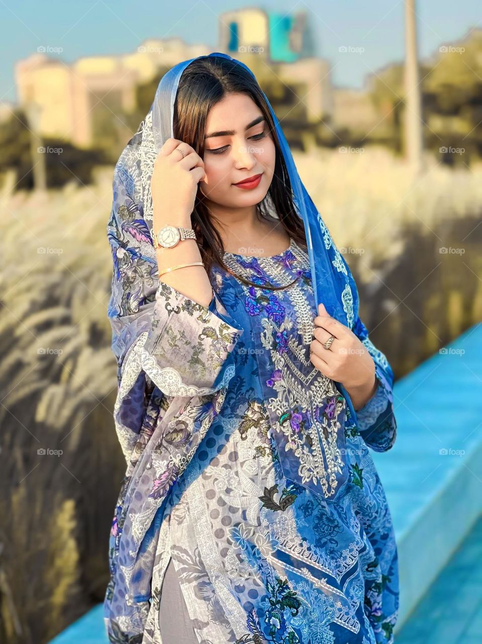 Portrait of a woman wearing traditional blue clothes with floral motifs