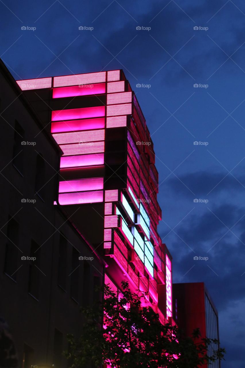 A pink colored lighted house at night