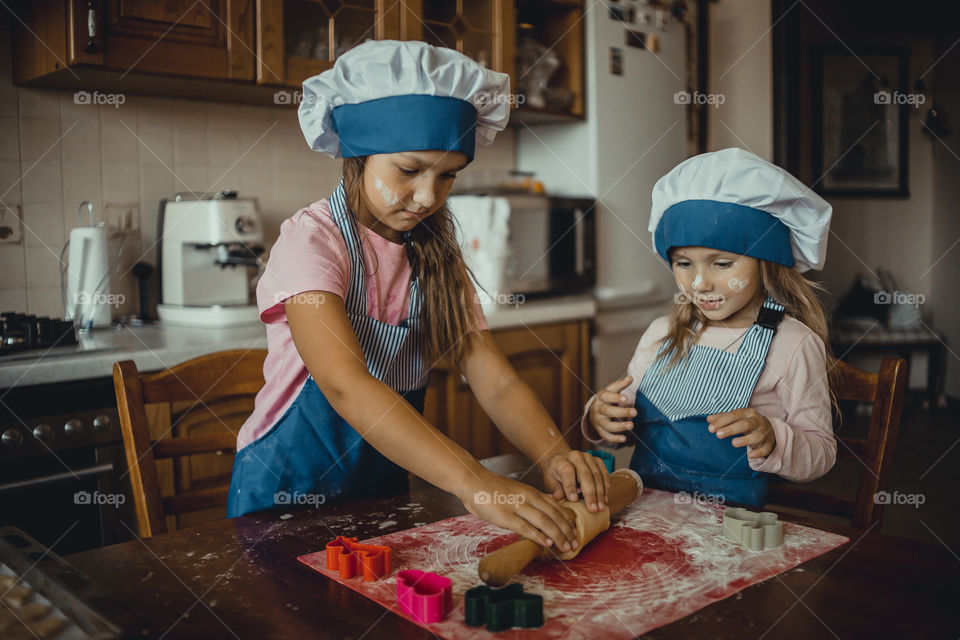 Little sisters cooking the biscuits 