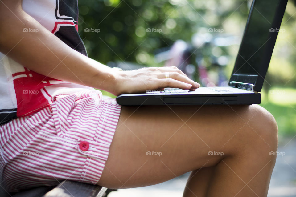 woman working in park. woman working on laptop while enjoying beautiful day in park