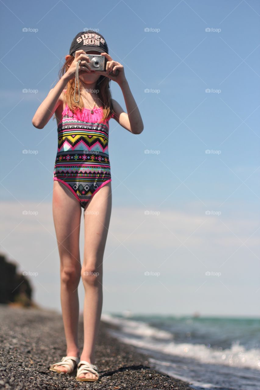 Girl takes pictures on the beach