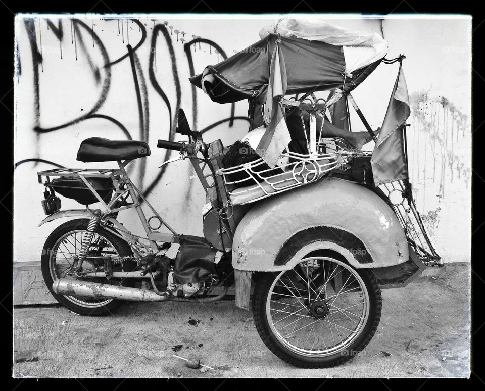 A man sleeping in a rickshaw 