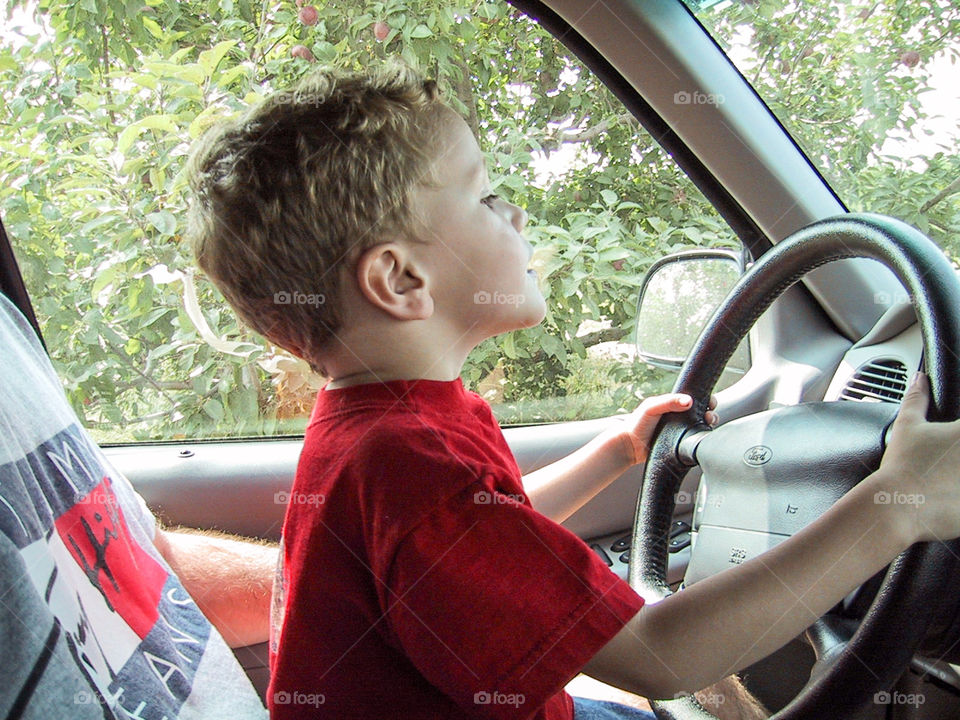 Helping drive from daddies lap. 