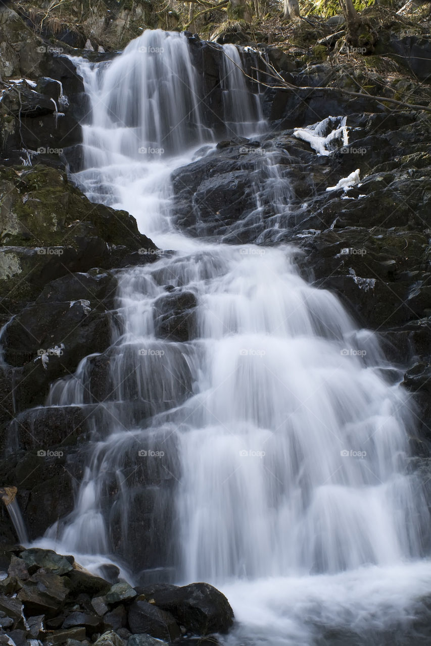 white waterfall among black rocks