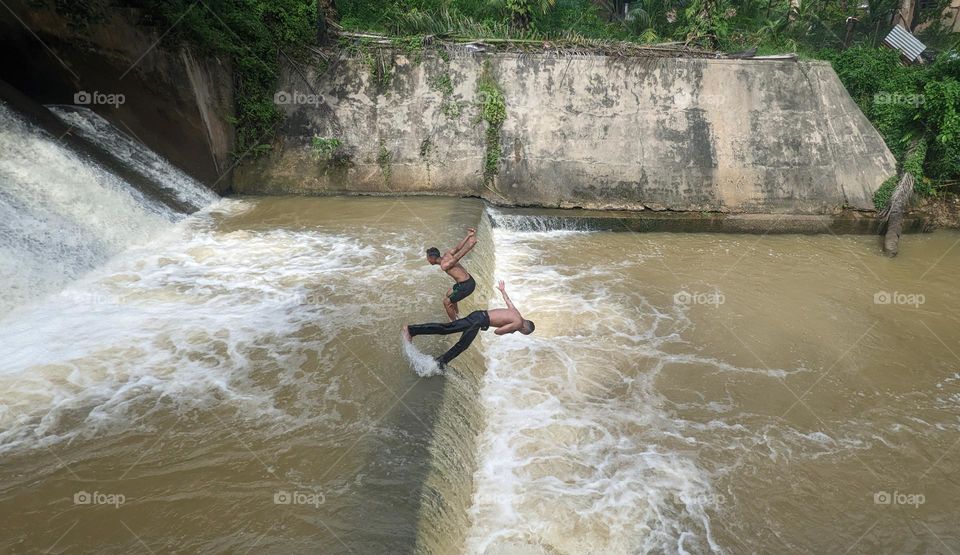 two boys are playing at floodgate danau buatan Pekanbaru.