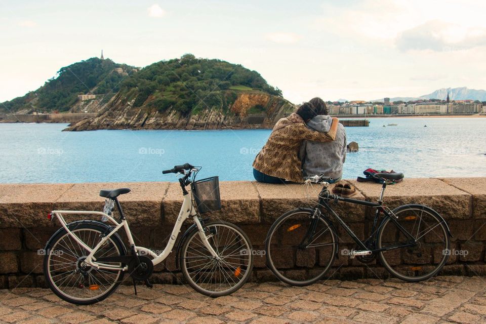 Couple sitting on retaining wall