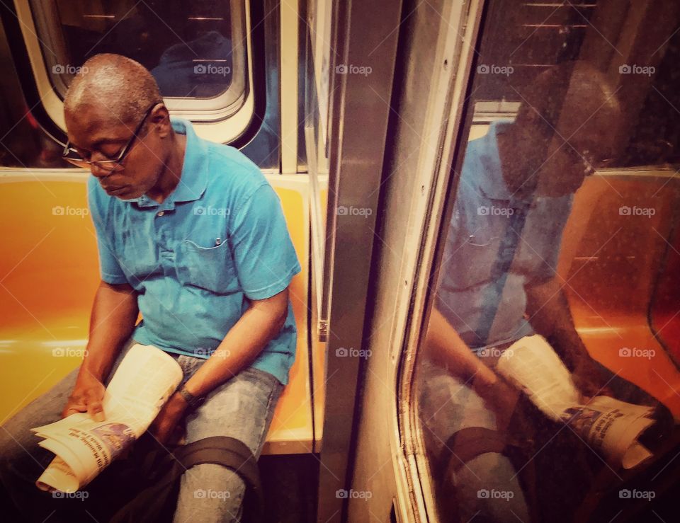 Man in the subway reading newspaper 