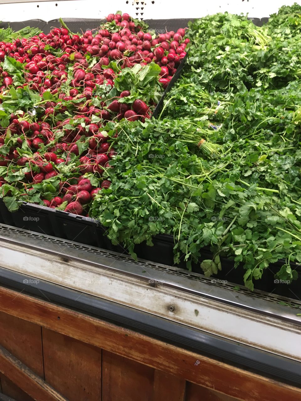 Red and green vegetables and herbs on display 
