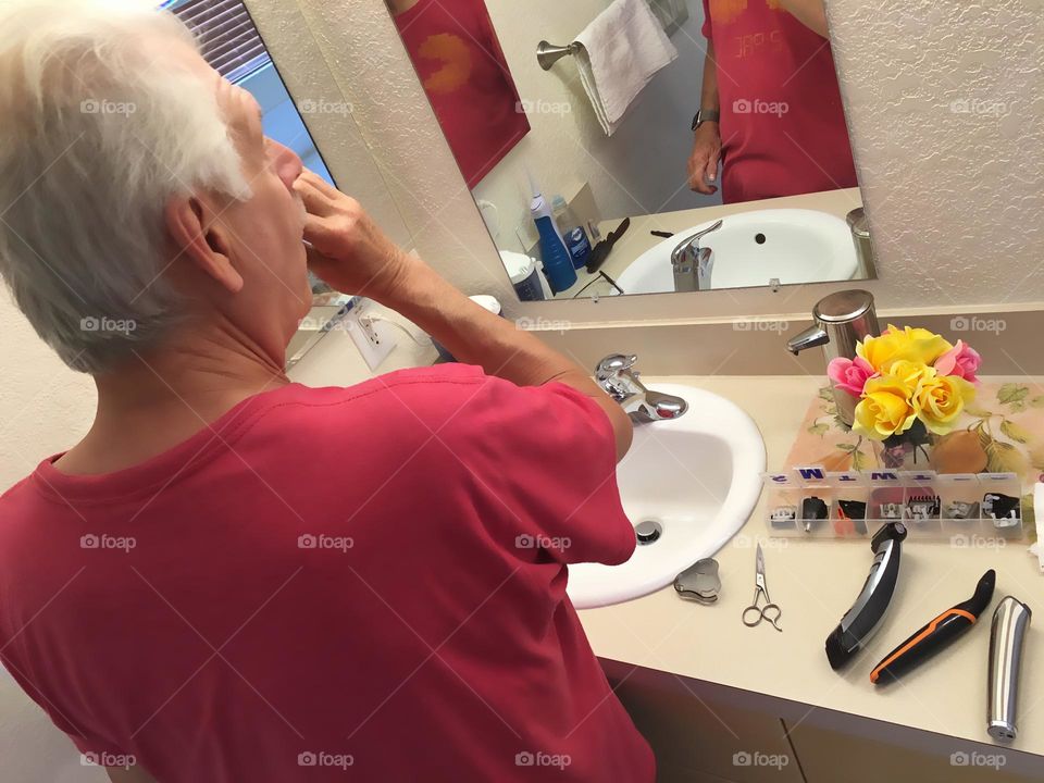 Man shaving in the mirror.
