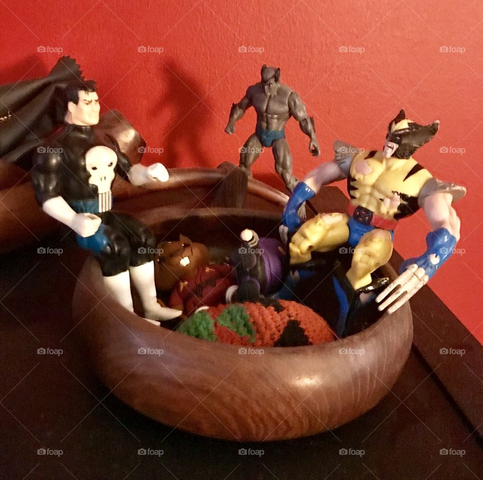 Superhero action figures grouped together in wooden bowl