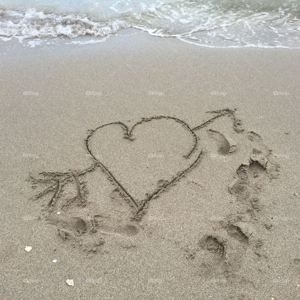 Writing in the sand heart with arrow aren't