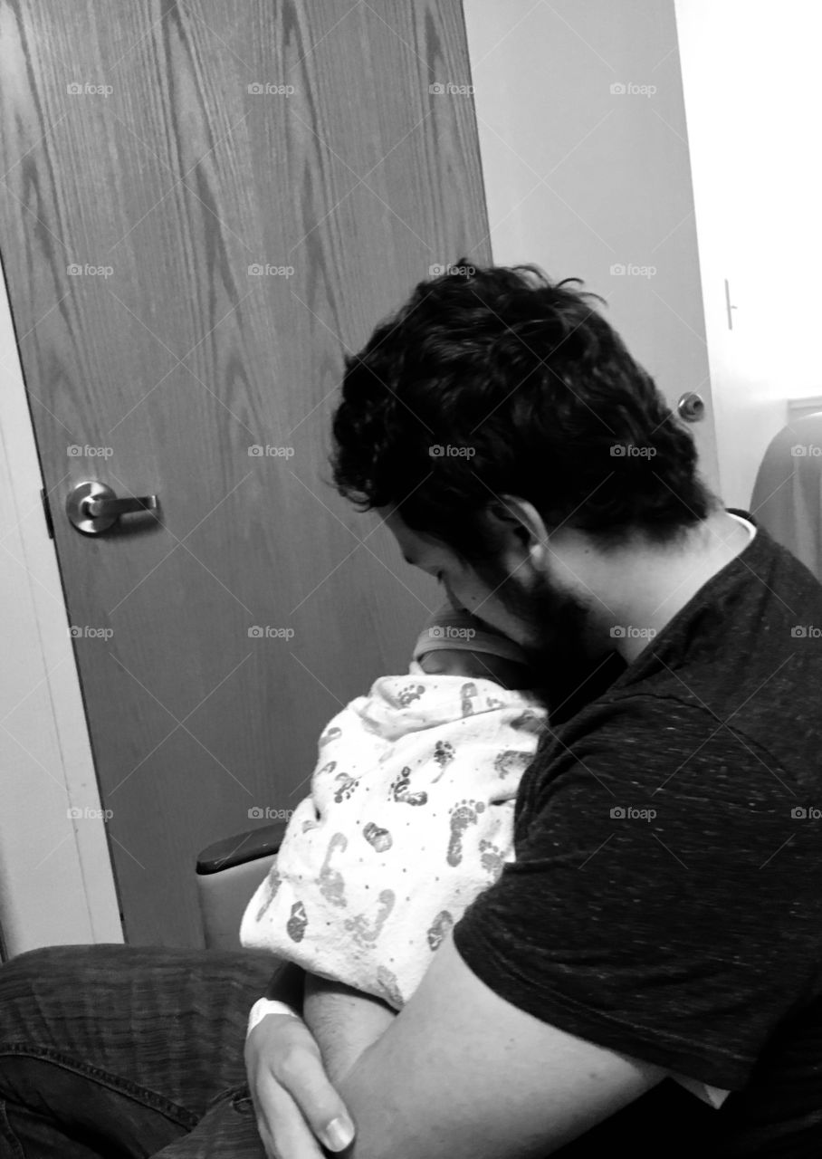 The birth of a child is extremely memorable! This loving father spending some time with his newborn son is picture perfect. That hospital room was so peaceful.