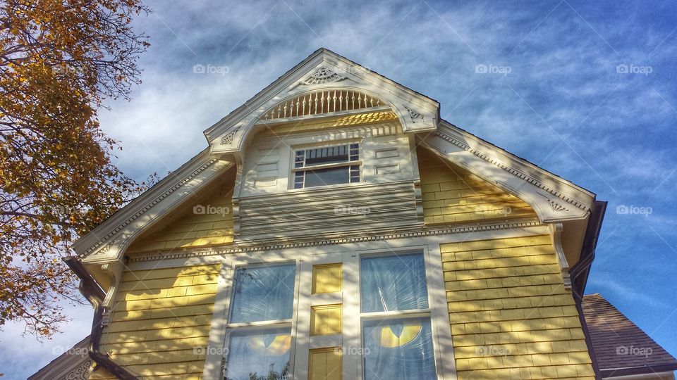 Yellow Victorian. Cat Eyes in Window