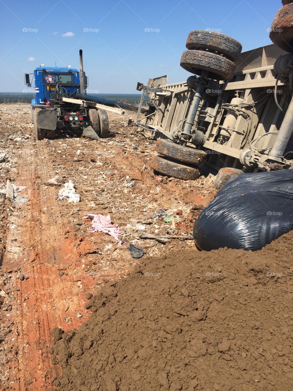 Republic Services tractor trailer in McCarty Landfill with a rolled over trailer 