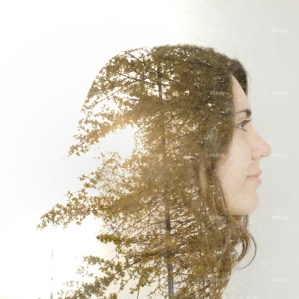 Double exposure of beautiful young woman and tree