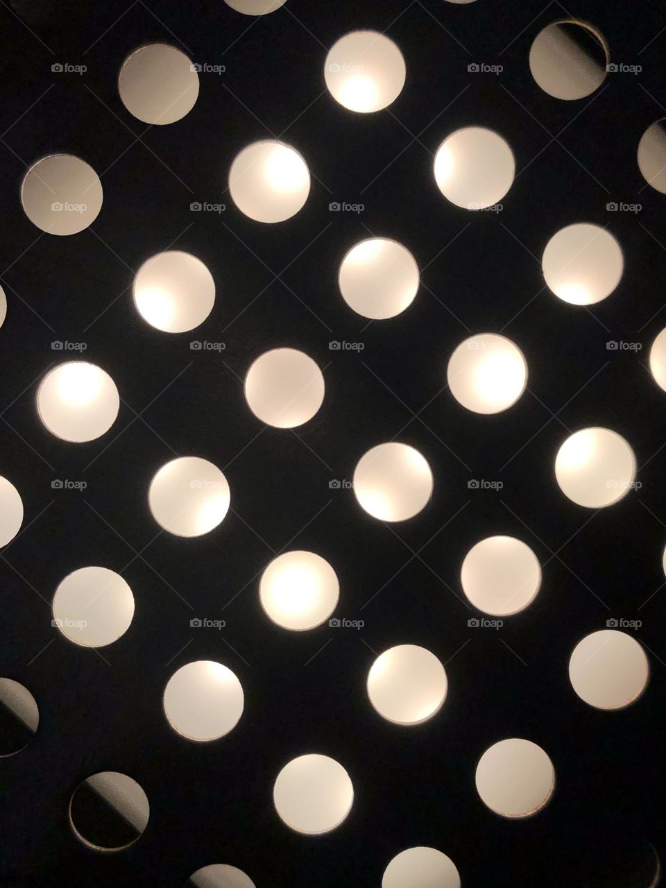 Polka dots of light on a coffee maker drip pan