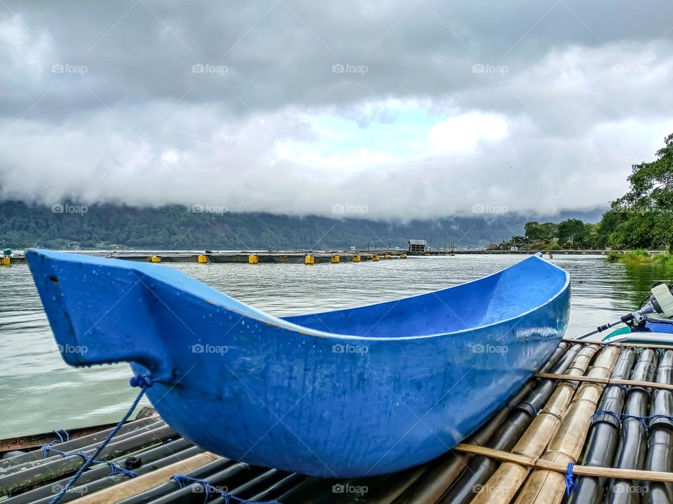 authentic blue canoe boat in the middle of a dazzling green lake