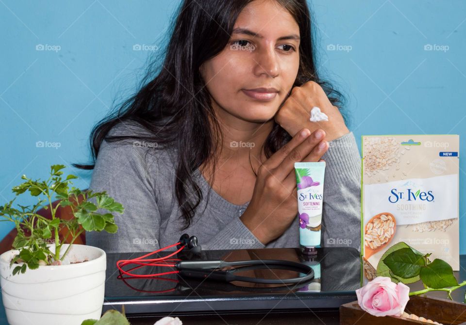 Woman applying ST Ives hand cream at her work place.