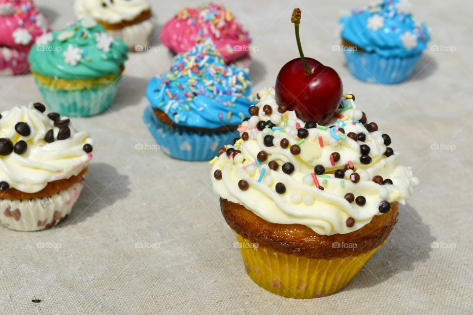 Cherry and sprinkles with cream on muffin