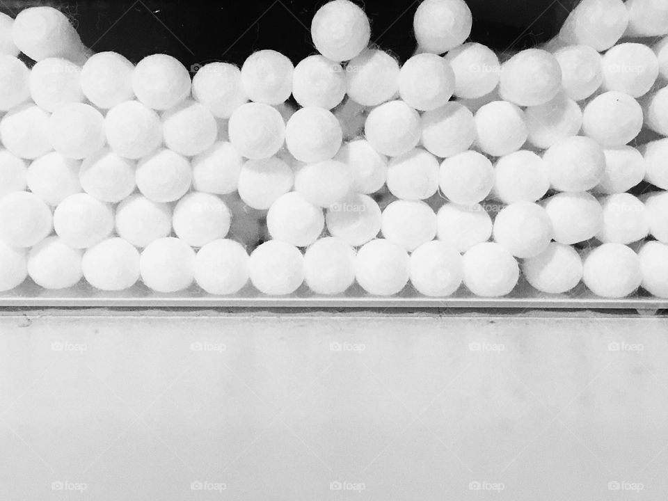 Many cotton buds inside a plastic case on the white table.