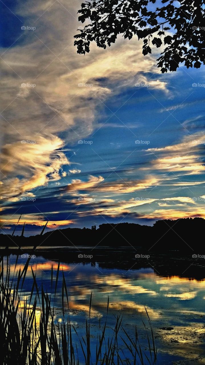 Dramatic sky reflecting on lake during sunset