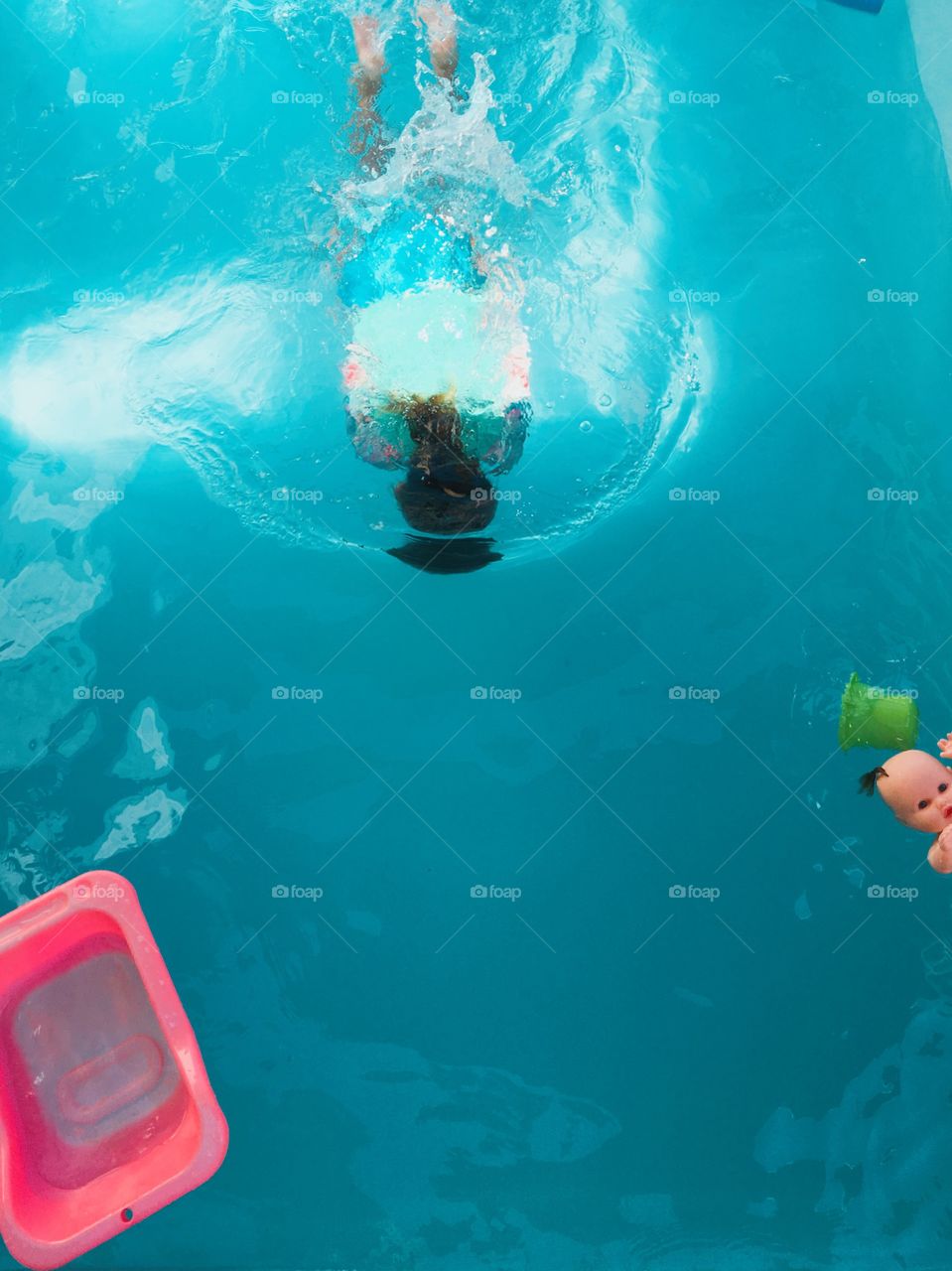 Child swimming in the pool on a summer day in Brazil