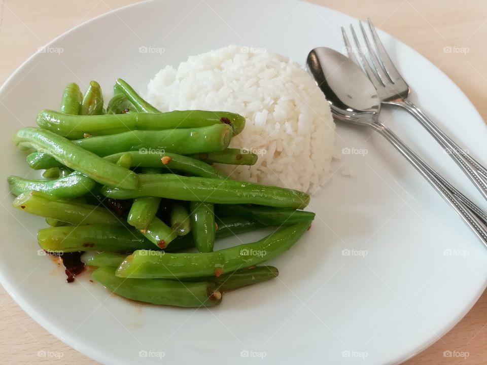 Thai food, green beans in fish sauce and streamed rice.