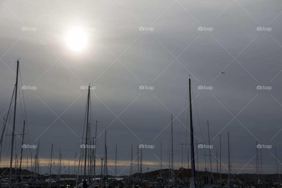 Silhouette of boats over cloudy sky