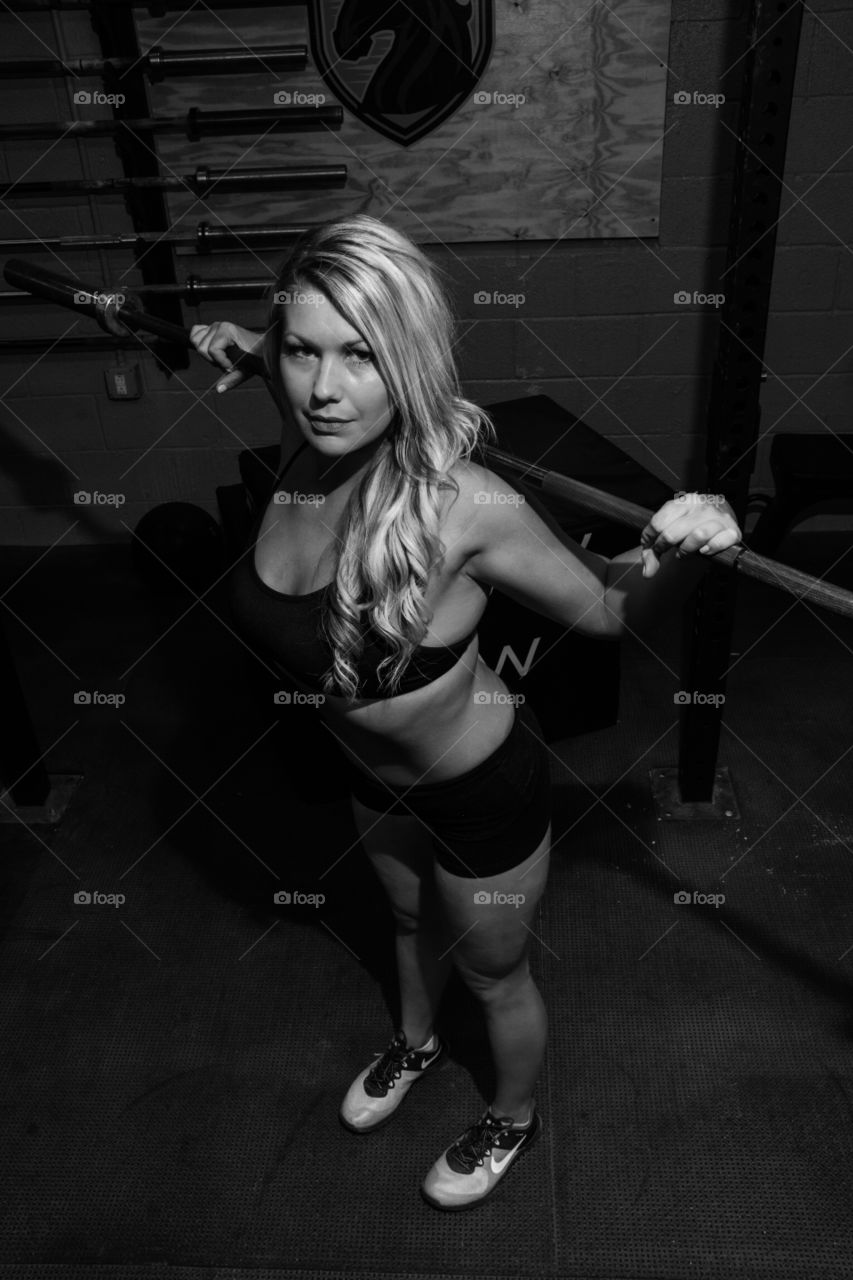 Fitness woman exercising with barbell in gym