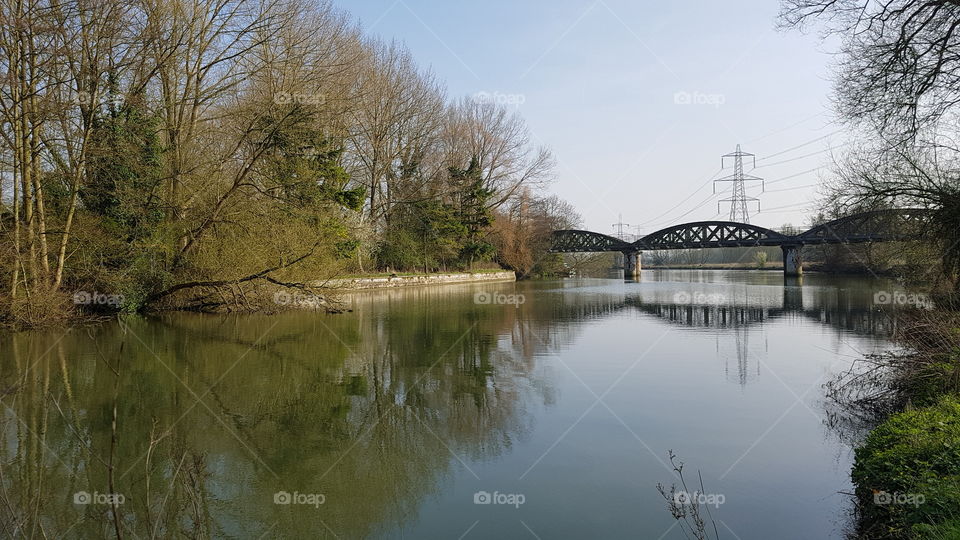 Old railway bridge over river in English countryside