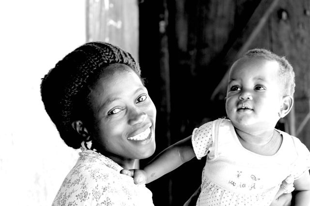Mother and Daughter . Came across this woman Brest feeding while visiting an orphanage in Uganda. She had the most welcoming smile. 