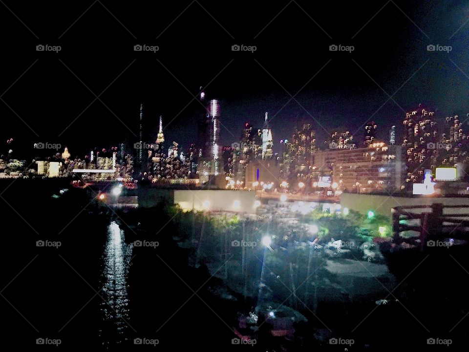 Long Island City, Queens, NY photographed in October 2020 late at night from the Pulaski Bridge and at the far horizon you can see the illuminated Manhattan skyline and the Empire State Building. Hypnotic Productions