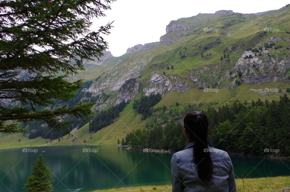 Young woman looking at lake with mountains