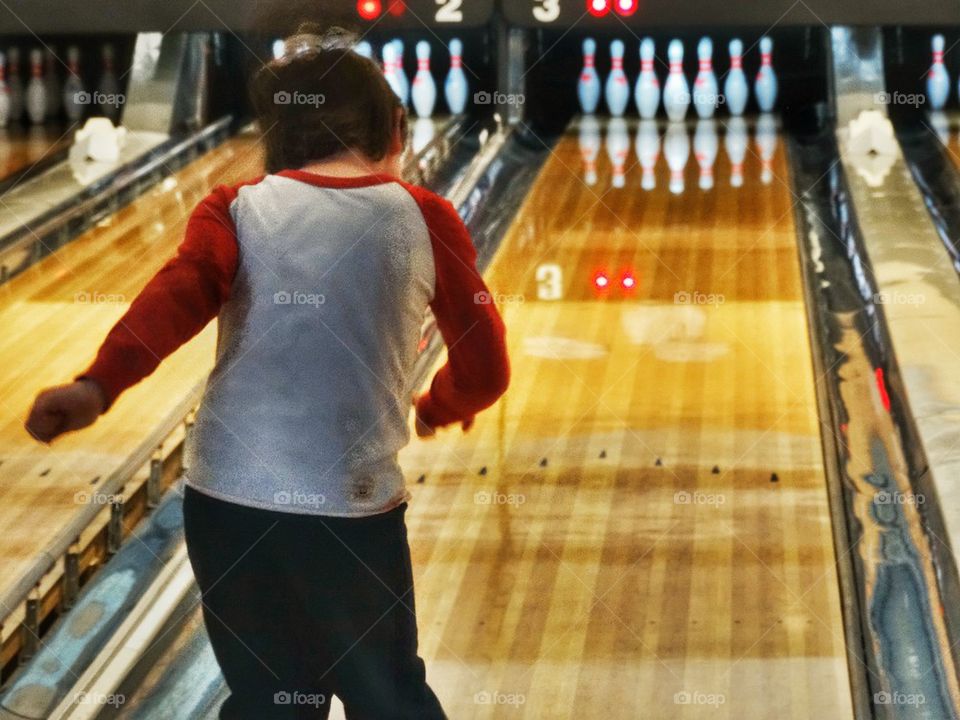 Young Bowling Champion. Boy Tossing A Bowling Ball Down The Lane
