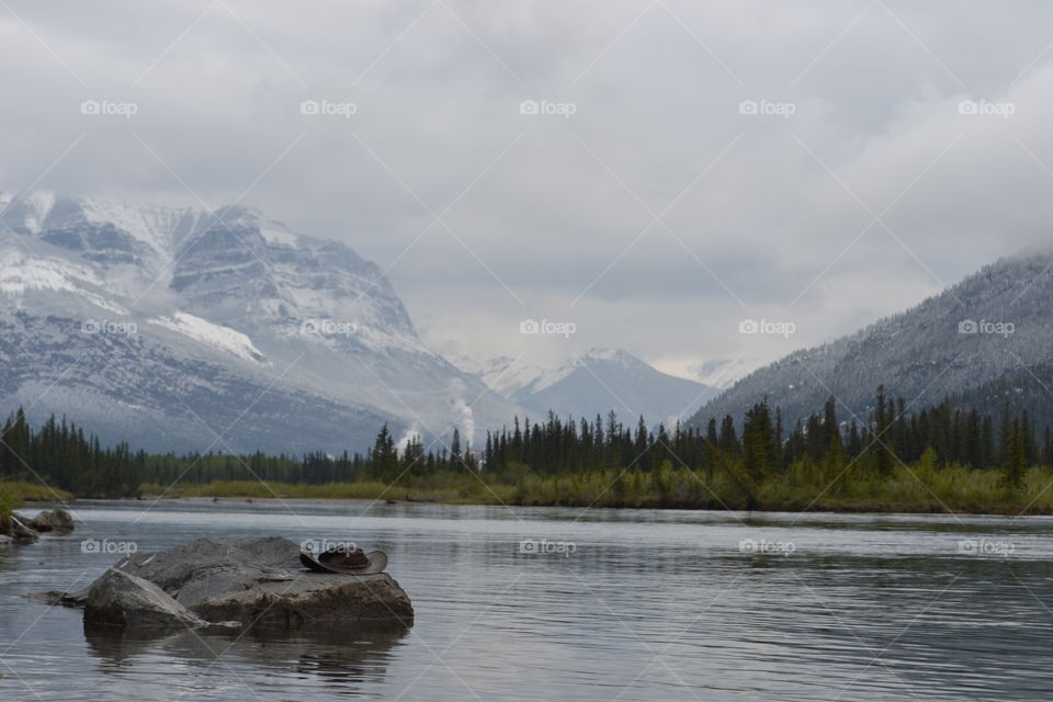 Cowboy hat on a rock on the lake in Canada's remote Rocky Mountain wilderness 