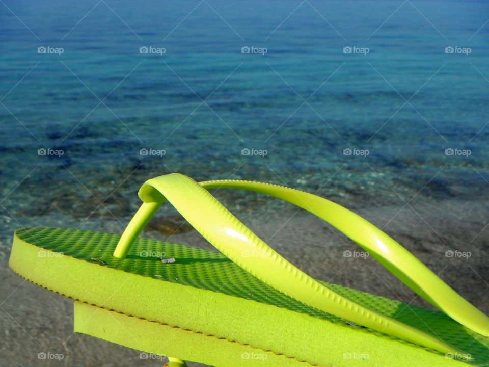 Green flip-flop on beach
