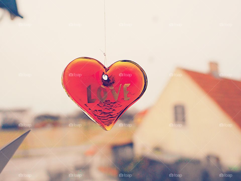 Red heart made of glass hanging in a window 