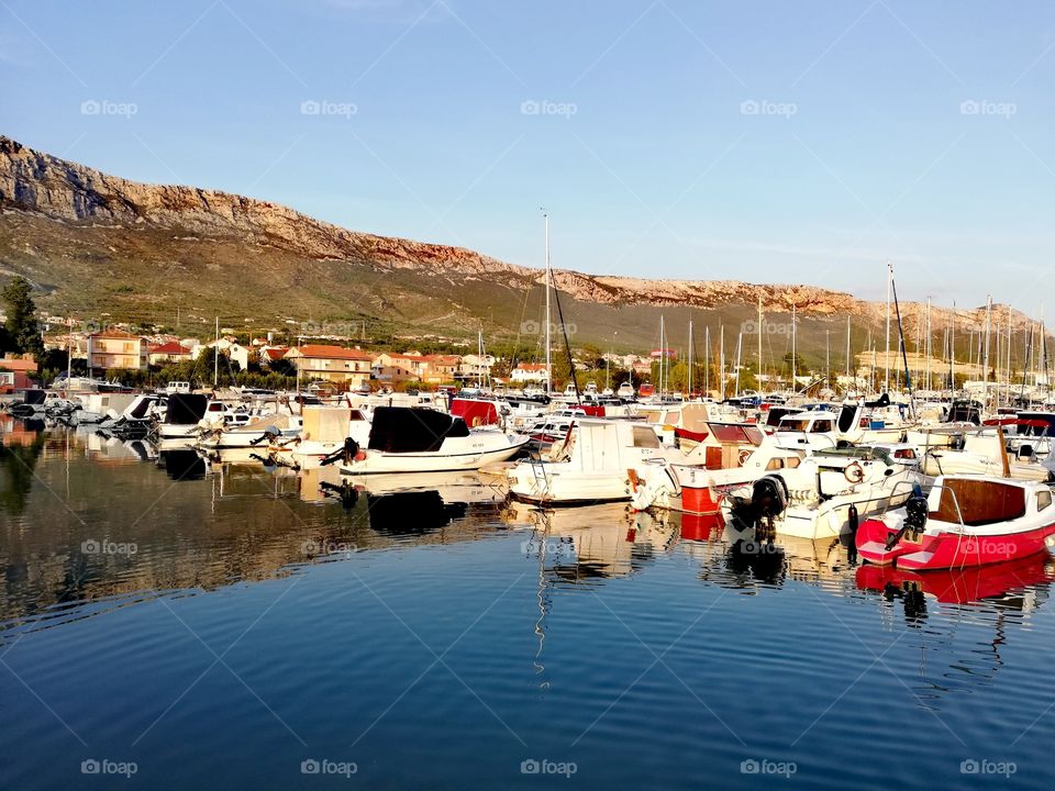 Boats in Kastel Sucurac harbor near Split, Croatia, Adriatic Sea in the foreground, the southern Velebit mountains in the background
