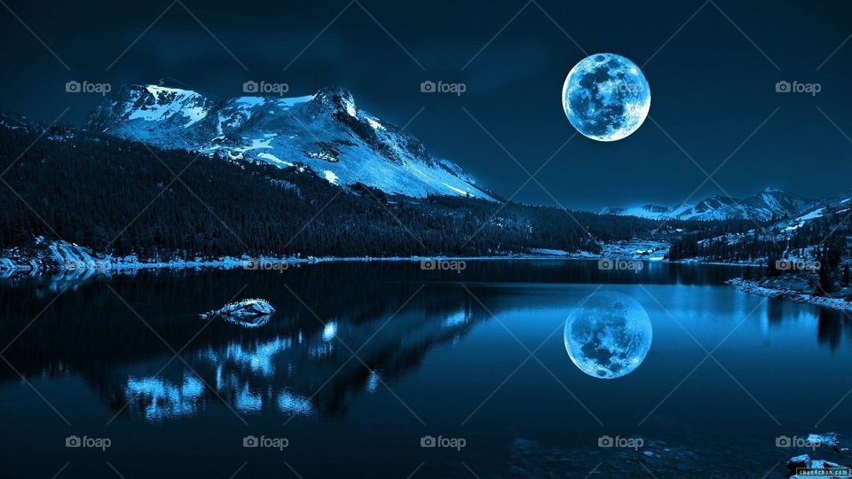 Snow in the mountains and the moon reflection on the water