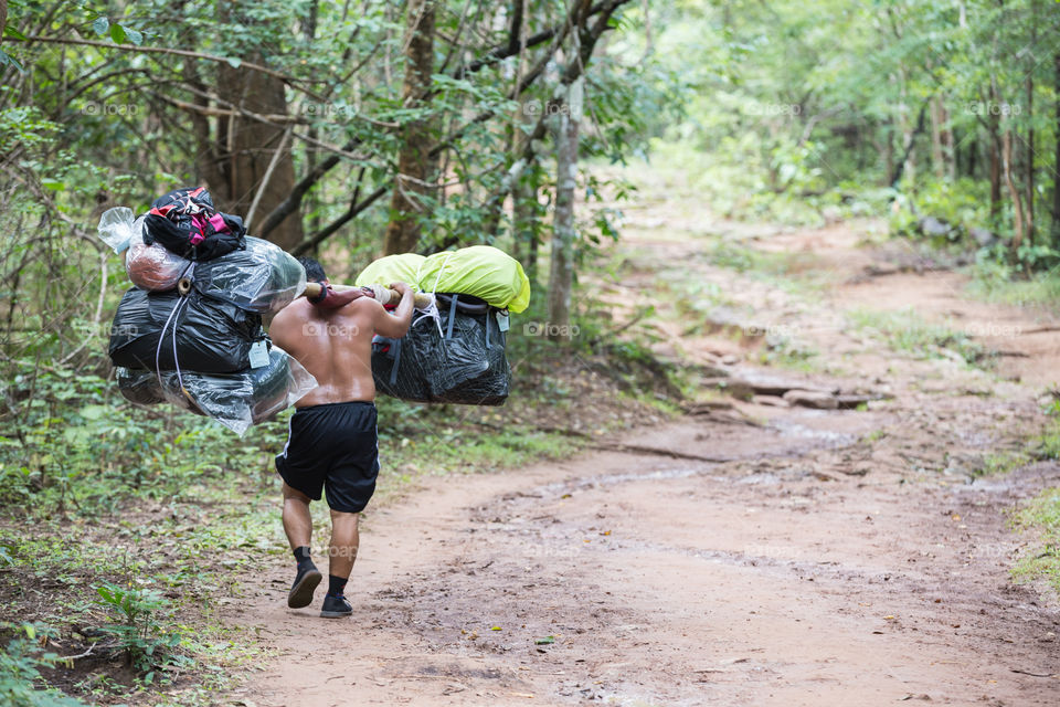 Man carrying a lot of bag in their shoulder in Phu Kradueng national park Loei Thailand 