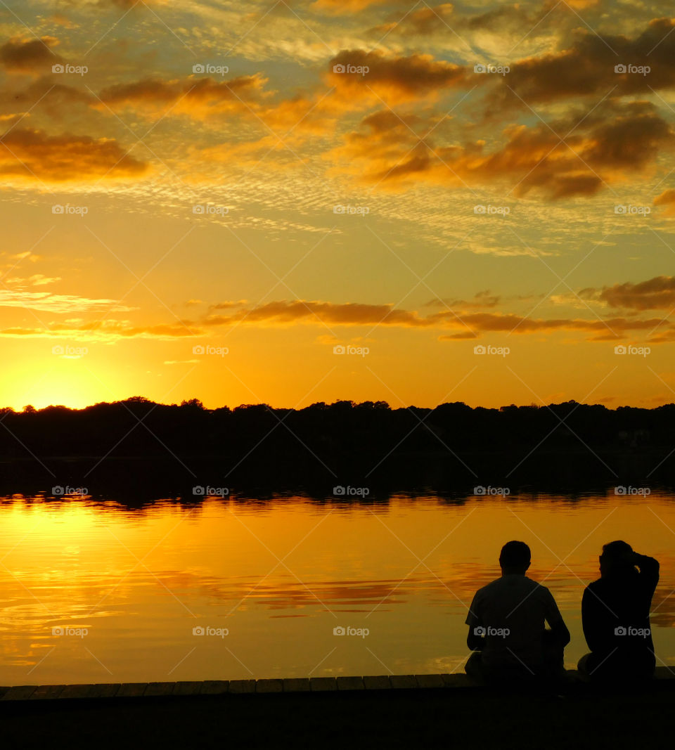 Silhouette of two people at sea