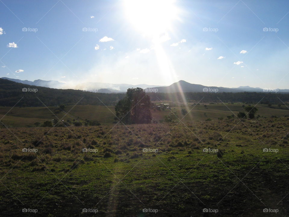 Afteenoon rays of sunshine from over the mountains, onto the land in country Queensland, Australia