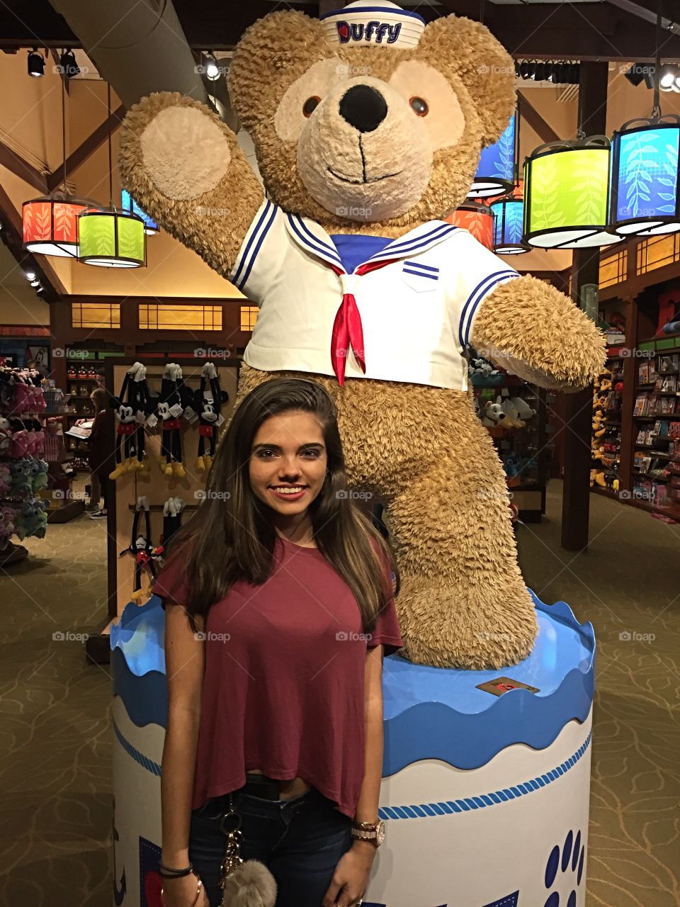 Woman standing behind teddy bear in shop