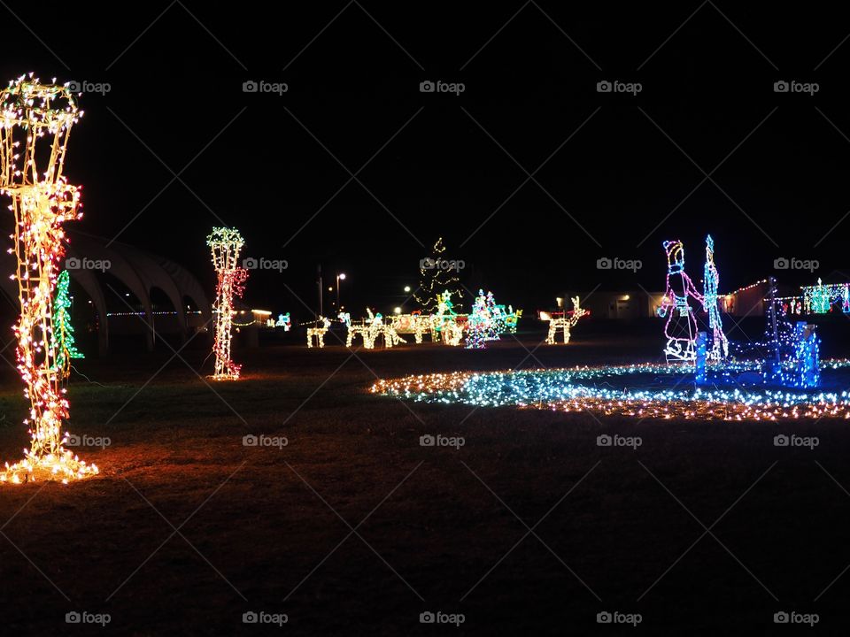 A large outdoor Christmas light display at night in the winter. 
