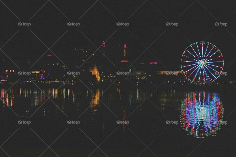 A bright carnival fully reflected onto a lake