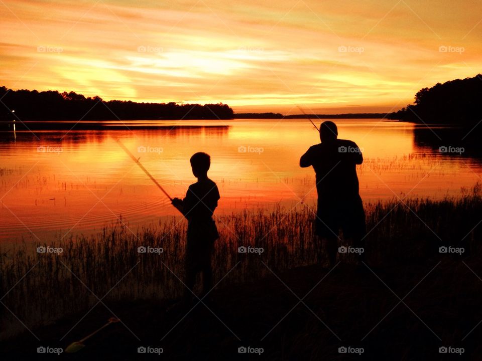 Silhouette of people doing fishing rod
