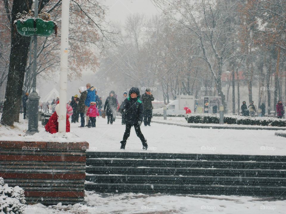 children playing snowballs in a winter park