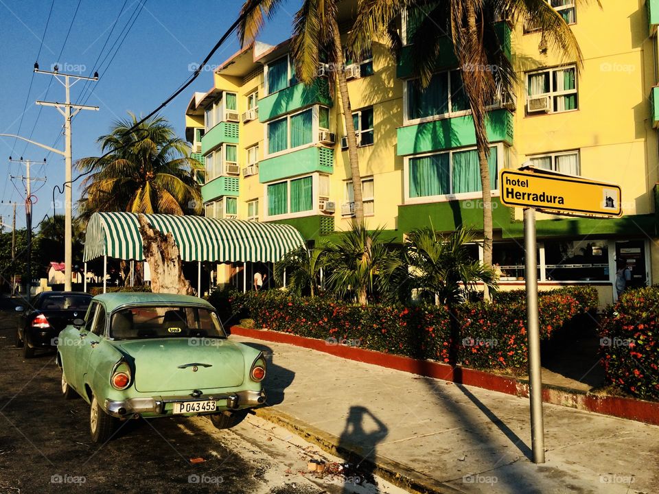A cuban hotel with a car parked outside of it